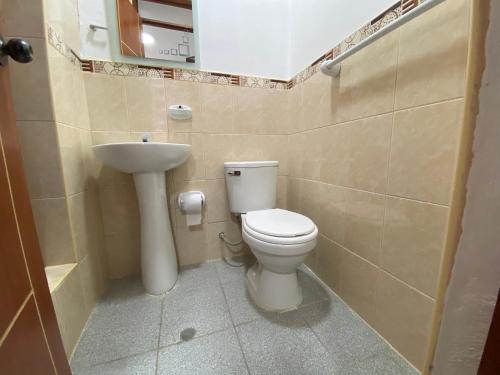 a bathroom with a toilet and a sink at Hostal Venus - Nueva Imagen in Huacho