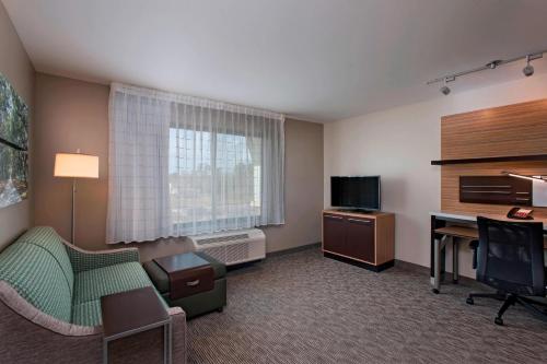 a hotel room with a bed and a desk and a television at TownePlace Suites by Marriott Slidell in Slidell