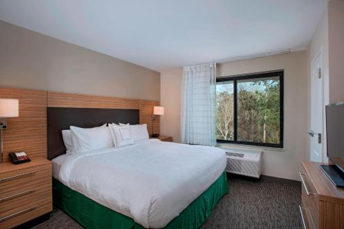 a hotel room with a large bed and a window at TownePlace Suites by Marriott Slidell in Slidell