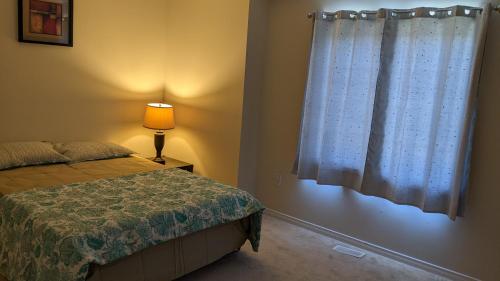 a bedroom with a bed and a window at The Warm Welcome Suite in Thorold
