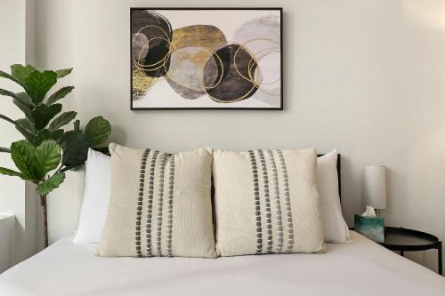 1 cama con almohadas blancas y una foto en la pared en Chic and Roomy Studio Apt in the Near North Side - Chestnut 16D en Chicago