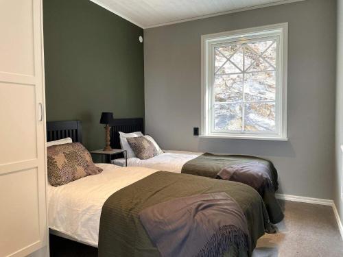 1 dormitorio con 2 camas y ventana en Holiday home UDDEVALLA XXII, en Sundsandvik