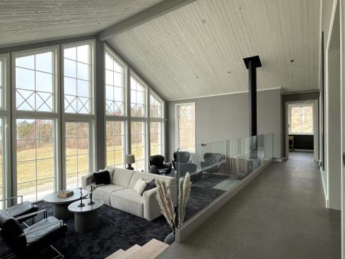 a living room with a couch and chairs and windows at 8 person holiday home in UDDEVALLA-By Traum in Sundsandvik