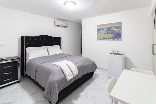 a bedroom with a bed and a table and a desk at Hotel Señorial in Santo Domingo