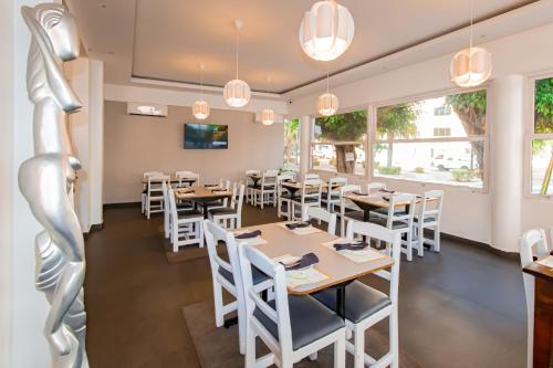 a restaurant with wooden tables and white chairs at Hotel Señorial in Santo Domingo