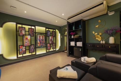sala de estar con sofá y cuadros en la pared en Madelise Palace Hotel & Spa, en Hanói