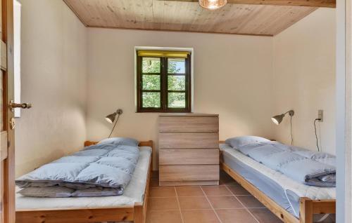 2 camas en una habitación con ventana en Fuglsang, en Tranekær
