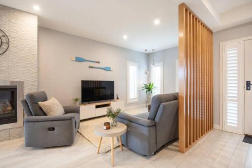 a living room with two chairs and a television at Family Tides Beach House in Rosebud