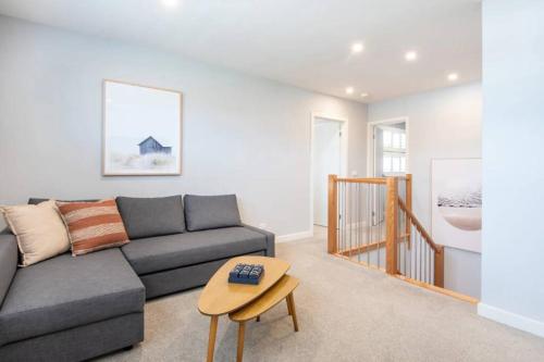a living room with a couch and a table at Family Tides Beach House in Rosebud