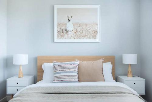 a bedroom with a bed with two night stands and two lamps at Family Tides Beach House in Rosebud