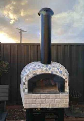 a brick oven sitting outside in a yard at Family Tides Beach House in Rosebud
