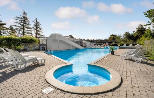 a swimming pool with two chairs and a slide at 2 Bedroom Gorgeous Home In Humble in Humble