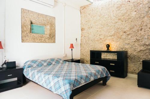 a bedroom with a bed and a picture on the wall at Guaya Hostel in Mérida