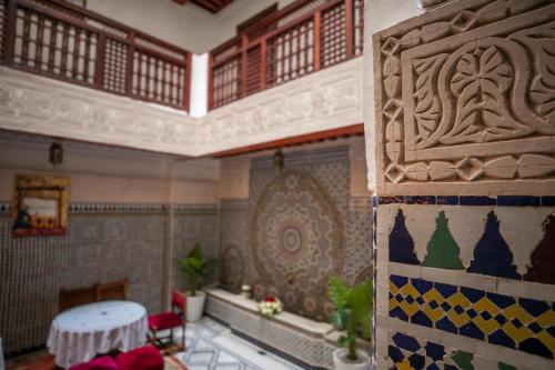 una habitación con una mesa y una pared con un patrón en Riad Anis Fes, en Fez