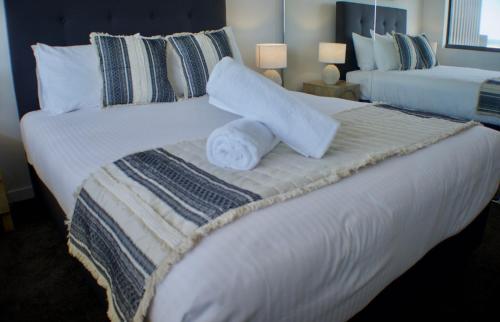 a large white bed with two towels on it at COASTAL ESCAPE@ The Cosmopolitan Unit 20806 in Maroochydore