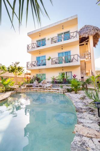 a hotel with a swimming pool in front of a building at Jaakbal Tulum in Tulum