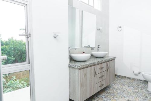 a bathroom with two sinks and a large window at Casa finca con piscina in Santa Marta
