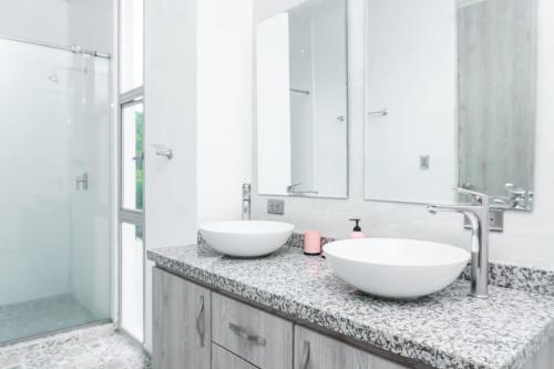 two white sinks on a counter in a bathroom at Casa finca con piscina in Santa Marta