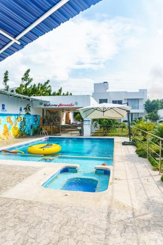 a pool at a resort with an umbrella at Casa finca con piscina in Santa Marta