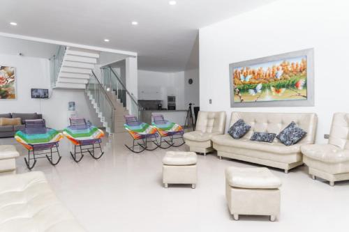 a living room with a couch and tables and chairs at Casa finca con piscina in Santa Marta