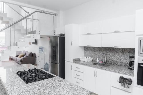 a kitchen with a stove top oven next to a couch at Casa finca con piscina in Santa Marta
