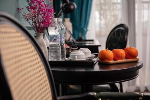 a table with oranges on a table with chairs at Madelise Palace Hotel & Spa in Hanoi