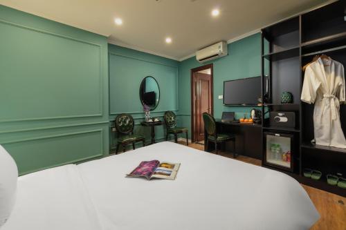 a bedroom with a bed and a desk and a mirror at Madelise Palace Hotel & Travel in Hanoi