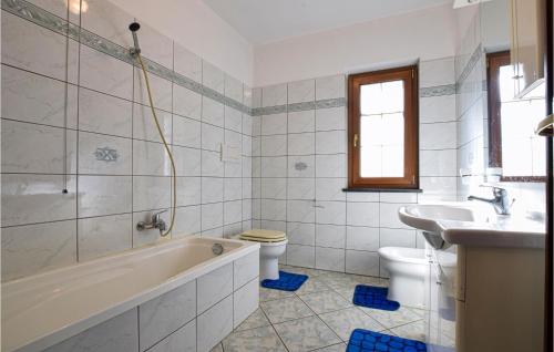 y baño con bañera, aseo y lavamanos. en 2 Bedroom Awesome Home In Chiaravalle, 
