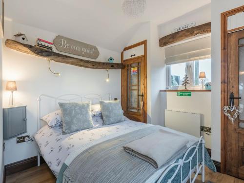 a bedroom with a bed with blue pillows at Little Pines Lodge in Rushton Spencer