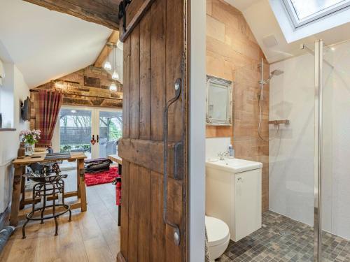 a bathroom with a shower and a toilet and a sink at Little Pines Lodge in Rushton Spencer