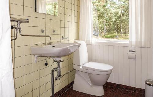 a bathroom with a toilet and a sink and a window at Stunning Home In Nex With 3 Bedrooms And Wifi in Vester Sømarken