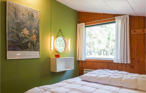 um quarto com paredes verdes, uma cama e uma janela em Gorgeous Home In Nex With Kitchen em Vester Sømarken
