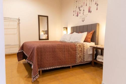 1 dormitorio con 1 cama grande y espejo en Departamento Rustico 1, en Tarija