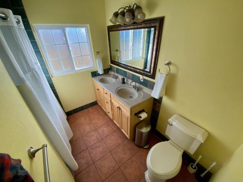 a bathroom with a sink and a toilet and a mirror at Newer Ranch with Pool and Hot Tub near the Strip and Freemont street. in Las Vegas