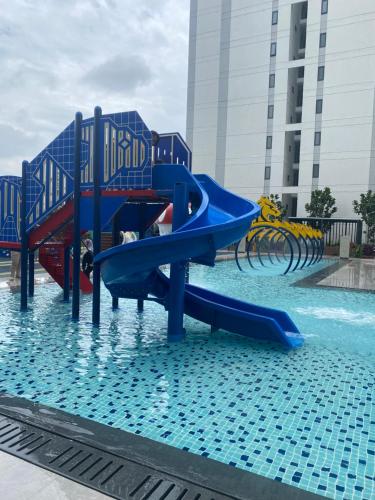 un tobogán de agua azul en una piscina en jugi suite @ Horizon Sepang KLIA en Sepang