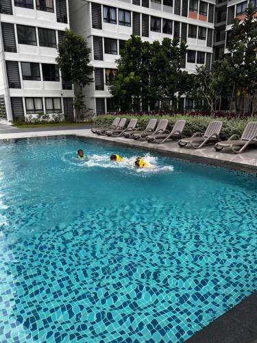 two people swimming in a swimming pool in a building at jugi suite @ Horizon Sepang KLIA in Sepang