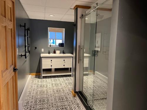 a bathroom with a sink and a glass shower at Catskills Cabin: Hot Tub, Firepit, WFH, Ski, Games in Lexington