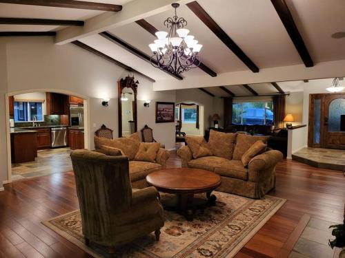 una gran sala de estar con sofás y una mesa. en High on the Hill Serene View Home on Avocado Grove, en Fallbrook