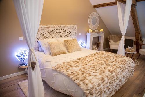 um quarto com uma grande cama branca com cortinas em Les alouettes em Caudry