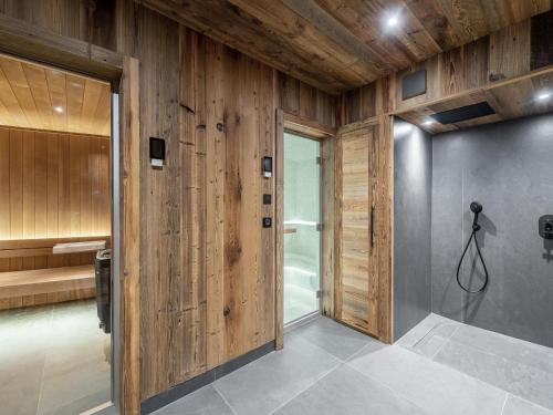 a bathroom with wooden walls and a walk in shower at Chalet Les Belleville, 8 pièces, 15 personnes - FR-1-570-25 in Saint-Martin-de-Belleville