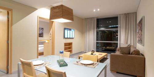 a dining room and living room with a table and chairs at Stadia Suites Mexico City Santa Fe in Mexico City