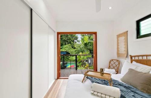 sala de estar con sofá blanco y ventana en Villa Oshea - Balinese Beachfront Escape with Pool, en Machans Beach
