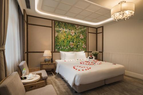 a hotel room with a large bed and a desk at La Passion Hanoi Hotel & Spa in Hanoi