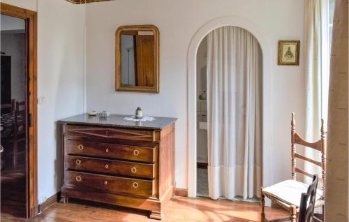 ein Badezimmer mit einer Holzkommode und einem Spiegel in der Unterkunft Beautiful Home In Aste-bon With Kitchenette in Aste-Béon