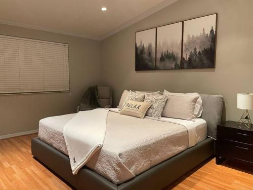 a bed in a bedroom with a picture on the wall at Luxurious Home, Accommodating Two Master Bedrooms with great amenities. in Tamiami