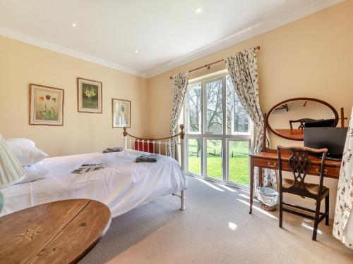 a bedroom with a bed and a desk and a window at The Fishing Lodge in Amesbury