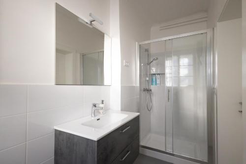 bagno bianco con lavandino e doccia di Epicenter - rooms & terrace a Lubiana