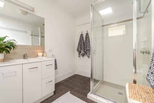 un baño con ducha y lavabo en Seashells - Popular Beach House, en Yamba