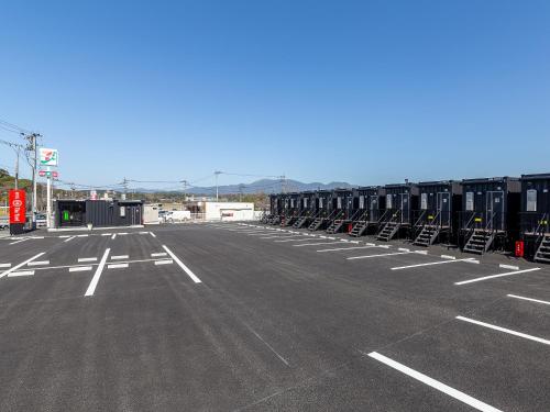 un estacionamiento vacío con filas de contenedores de transporte marítimo en HOTEL R9 The Yard Iizuka en Iizuka