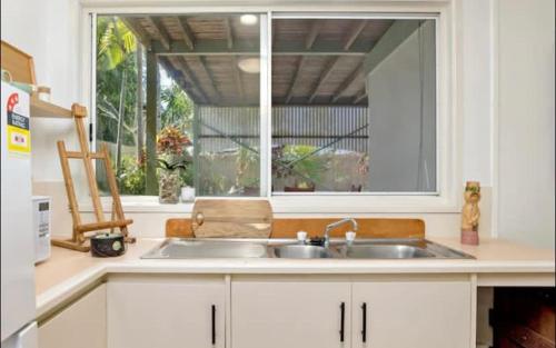 uma cozinha com um lavatório e uma janela em Villa Marshall em Machans Beach